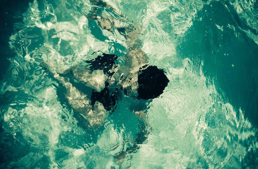 a man swimming in a pool of water.