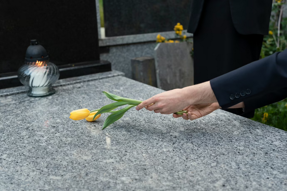 a person placing tulips on a grave.