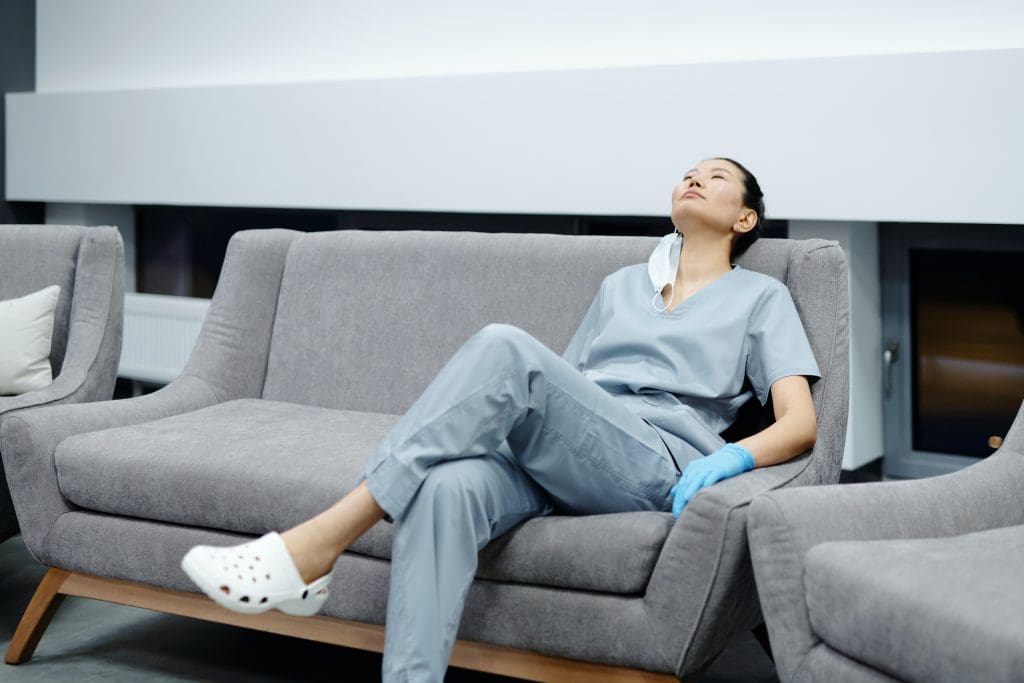 a woman sitting on a couch with her eyes closed.