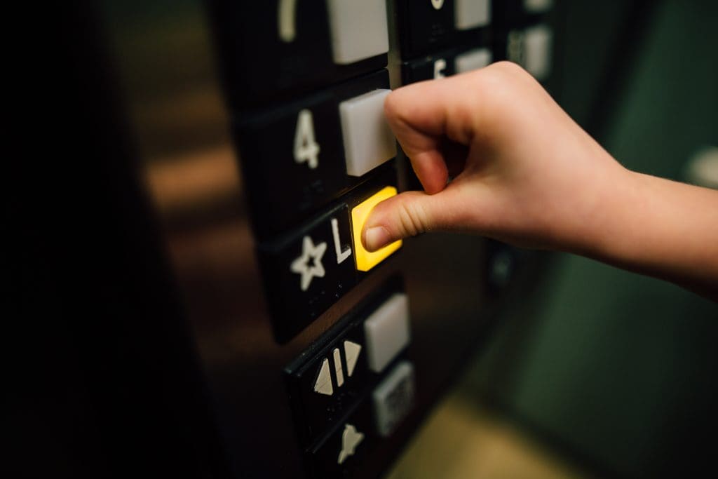 a person pressing a button on an elevator.
