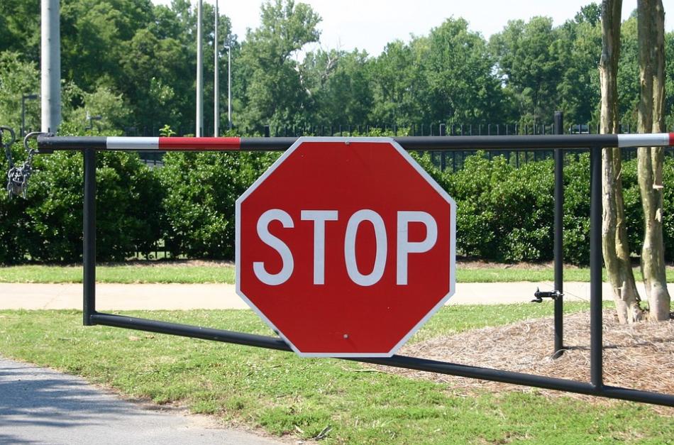 A fence displaying a stop sign, serving as a precautionary measure to prevent auto accident injuries.