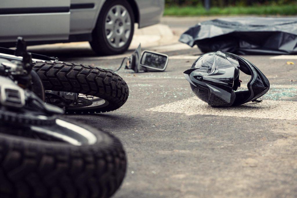 A motorcycle and a car on the side of the road.