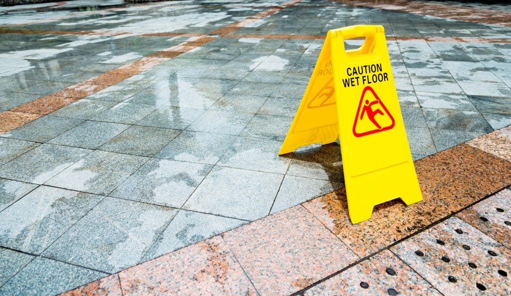 A yellow caution sign on a tiled floor.