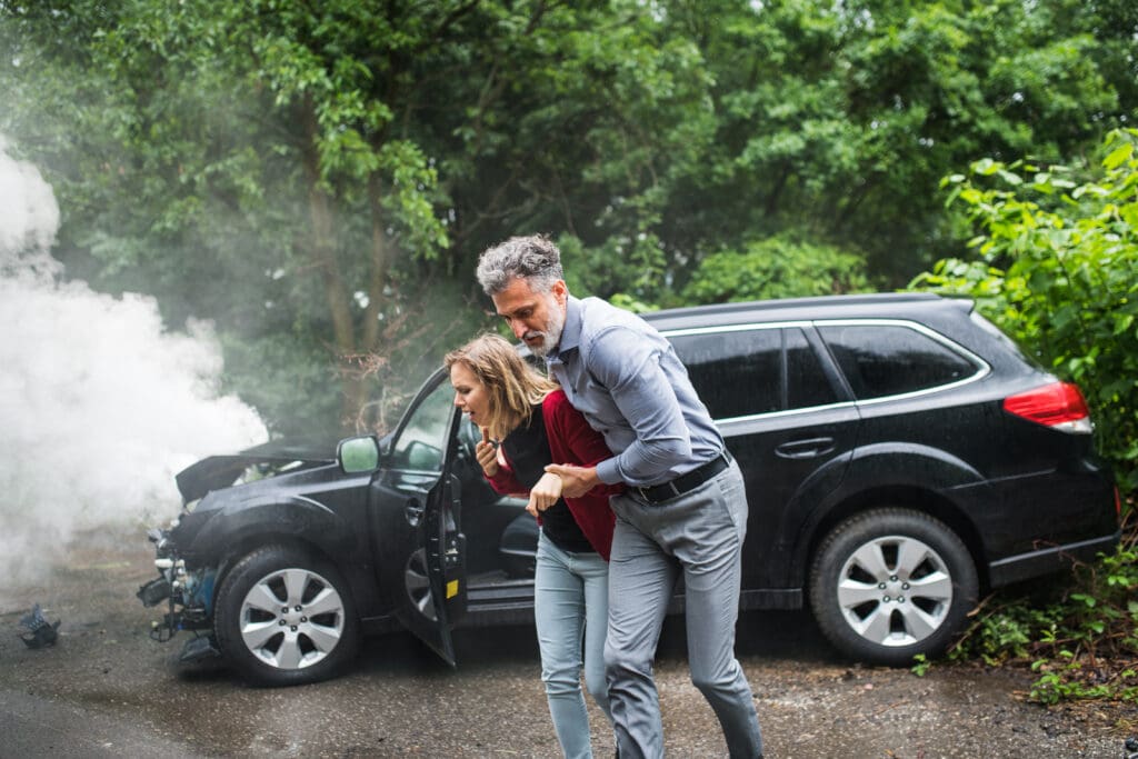 man helping woman from a car accident